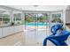 Bright sun room with views of the screened-in pool area and lush tropical landscaping at 13420 Rustic Pines S Blvd, Seminole, FL 33776