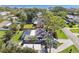 Overhead image of backyard with screened-in pool, tiki hut and white carport set amongst tropical foliage at 143 58Th S Ave, St Petersburg, FL 33705