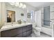 Bathroom featuring a double sink vanity, tub with shower, and stylish light fixture at 143 58Th S Ave, St Petersburg, FL 33705