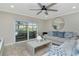 Bright living room featuring tile floors, ceiling fan, modern decor, and views of the backyard pool at 15112 Alexis Dr, Tampa, FL 33624