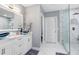 Bathroom with double sink vanity, stylish fixtures, and glass-enclosed shower with marble accents at 16316 Silent Sands Ln, Odessa, FL 33556