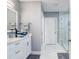 Bright bathroom with marble walk-in shower, white cabinets, and blue glass sink at 16316 Silent Sands Ln, Odessa, FL 33556