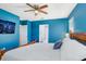 Blue bedroom featuring bed, ceiling fan, and flat screen television at 16316 Silent Sands Ln, Odessa, FL 33556