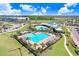 An aerial view of the community pool showcases lush surroundings and ample lounge areas for residents at 16316 Silent Sands Ln, Odessa, FL 33556