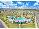 Aerial view of a community pool with lounge areas and lush landscaping, perfect for relaxation and recreation at 16316 Silent Sands Ln, Odessa, FL 33556