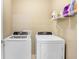 Functional laundry room with a side-by-side washer and dryer and storage shelf at 16316 Silent Sands Ln, Odessa, FL 33556
