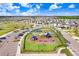 Aerial view of a community playground with modern equipment, surrounded by lush green space and parking at 16316 Silent Sands Ln, Odessa, FL 33556