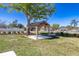 Backyard featuring a wooden gazebo and a mature shade tree in landscaped corner lot at 1766 10Th Sw St, Largo, FL 33778