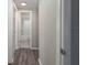 Hallway with wood-look floors leading to bathroom with a shower/tub combination at 1766 10Th Sw St, Largo, FL 33778