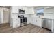 Updated kitchen featuring stainless appliances, white cabinets, laminate floors, and white subway tile backsplash at 1766 10Th Sw St, Largo, FL 33778