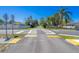 Clear street view of a crosswalk with yellow traffic markings amid a sidewalk and green grass at 1766 10Th Sw St, Largo, FL 33778