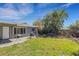 A spacious backyard features a grill, palm tree and concrete patio for outdoor entertaining at 1988 58Th N St, St Petersburg, FL 33710