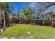 Large grassy backyard featuring trees and a wooden fence, offering a private outdoor space at 1988 58Th N St, St Petersburg, FL 33710
