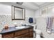 Traditional-style bathroom featuring mosaic tiles, a wood vanity, and a framed mirror, exuding classic charm at 1988 58Th N St, St Petersburg, FL 33710