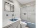 Cozy bathroom featuring a tub with sliding glass doors, a white vanity and simple fixtures at 1988 58Th N St, St Petersburg, FL 33710