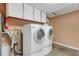 This laundry room features a white washer and dryer, cabinets, and is equipped with a fire extinguisher at 1988 58Th N St, St Petersburg, FL 33710