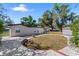 View of the back of the home with backyard, patio area, shade trees, and storage building at 202 New Hope Rd, Brandon, FL 33510