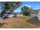 Large, fenced backyard featuring shade trees and multiple storage buildings at 202 New Hope Rd, Brandon, FL 33510