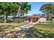Inviting single-Gathering home with lush green lawn, mature trees, and an American flag at 202 New Hope Rd, Brandon, FL 33510