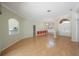 Spacious living room featuring wood floors, neutral walls, and an archway leading to the bright, modern kitchen at 2302 Azalea Dr, Palm Harbor, FL 34683