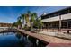 Exterior showcases a wooden dock, serene water views, and lush palm trees on a bright day at 2571 Cyprus Dr # 1-105, Palm Harbor, FL 34684