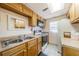Functional kitchen featuring wood cabinets, standard appliances, and tile flooring at 2571 Cyprus Dr # 1-105, Palm Harbor, FL 34684