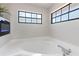 Bright bathroom featuring a jacuzzi tub, an electric fireplace, and black framed windows at 2715 Willow Oaks Dr, Valrico, FL 33594