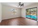 Bright bedroom with wood floors has glass doors leading to the outdoor pool area at 2715 Willow Oaks Dr, Valrico, FL 33594