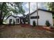 Inviting white brick home with contrasting black accents, dormer windows, and a well-maintained front yard at 2715 Willow Oaks Dr, Valrico, FL 33594