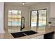 Modern sink with window and sliding glass doors overlooking the backyard pool at 2715 Willow Oaks Dr, Valrico, FL 33594