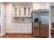 Kitchen featuring stainless steel refrigerator, white cabinetry, and mosaic tile backsplash at 2715 Willow Oaks Dr, Valrico, FL 33594