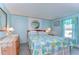 Bright bedroom with blue floral bedding, a side table, and natural light from a window at 3051 Shady Creek Dr, Wesley Chapel, FL 33543