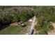 Overhead view displaying a charming home site surrounded by lush greenery and a long private driveway at 317 Old East Lake Rd, Tarpon Springs, FL 34688