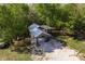 Aerial view of a home's exterior featuring a carport and a gravel driveway, surrounded by lush trees at 317 Old East Lake Rd, Tarpon Springs, FL 34688