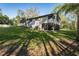 Two-story home with a screened in porch and lush green lawn at 317 Old East Lake Rd, Tarpon Springs, FL 34688