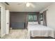 A minimalist bedroom featuring a cozy bed, grey dresser, and natural light, creating a serene space at 317 Old East Lake Rd, Tarpon Springs, FL 34688