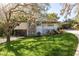Beautiful home with stone accents, carport, and a spacious green yard with mature trees at 317 Old East Lake Rd, Tarpon Springs, FL 34688