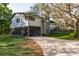 A charming two-story home with a stone chimney, screened in porch, and landscaped yard, situated on a well-manicured lawn at 317 Old East Lake Rd, Tarpon Springs, FL 34688