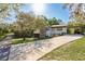 Inviting home with a long driveway, mature trees, carport, and meticulous landscaping at 317 Old East Lake Rd, Tarpon Springs, FL 34688