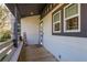 Welcoming front porch with stone accents, white railing, and cozy seating area with a 'Welcome' sign at 317 Old East Lake Rd, Tarpon Springs, FL 34688