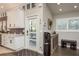 Modern kitchen boasts white cabinets, stainless appliances, and stylish tile backsplash with a view to the backyard at 317 Old East Lake Rd, Tarpon Springs, FL 34688