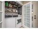 Bright laundry room with stylish shelving, modern washer and dryer, and sleek french doors at 317 Old East Lake Rd, Tarpon Springs, FL 34688