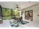 Outdoor sunroom with dining area features screened enclosure, offering the joy of outdoor dining with scenic backyard views at 317 Old East Lake Rd, Tarpon Springs, FL 34688