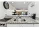 Modern kitchen with bright granite countertops and view of the open living room and terrace at 36750 Us 19 N # 17106, Palm Harbor, FL 34684