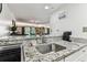 Granite countertops in the kitchen with stainless steel sink and view of the living room at 36750 Us 19 N # 17106, Palm Harbor, FL 34684