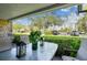 Inviting patio with table and chairs offers scenic views of lush green space and parked cars at 36750 Us 19 N # 17106, Palm Harbor, FL 34684