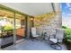Relaxing outdoor patio with chairs, table, and sliding glass door entrance to a beautifully decorated room at 36750 Us 19 N # 17106, Palm Harbor, FL 34684