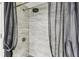 Updated shower features gray tile and modern fixtures behind a dark shower curtain at 36750 Us 19 N # 17106, Palm Harbor, FL 34684