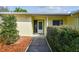 Inviting entryway with a storm door and a tidy walkway framed by green bushes, showcasing curb appeal at 4015 Mountain Springs Ln, Tampa, FL 33624