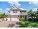 A beautifully landscaped two-story house features a three-car garage and a welcoming front porch at 4117 W Platt St, Tampa, FL 33609